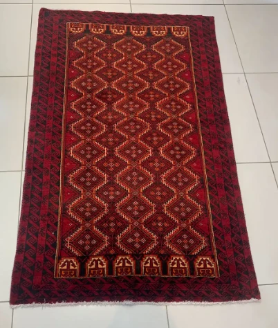 Claret red Bokhara rug with cream octagon medallion grid