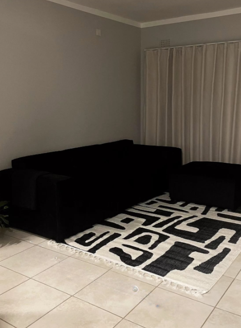 Black L-Shaped Sofa with Geometric Rug