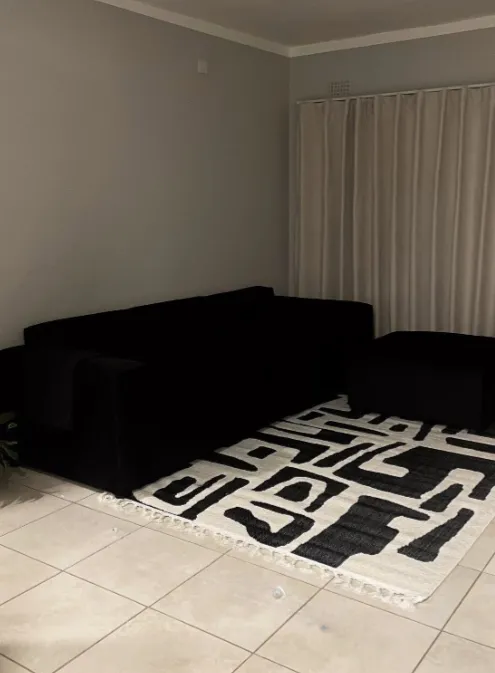 Black L-Shaped Sofa with Geometric Rug